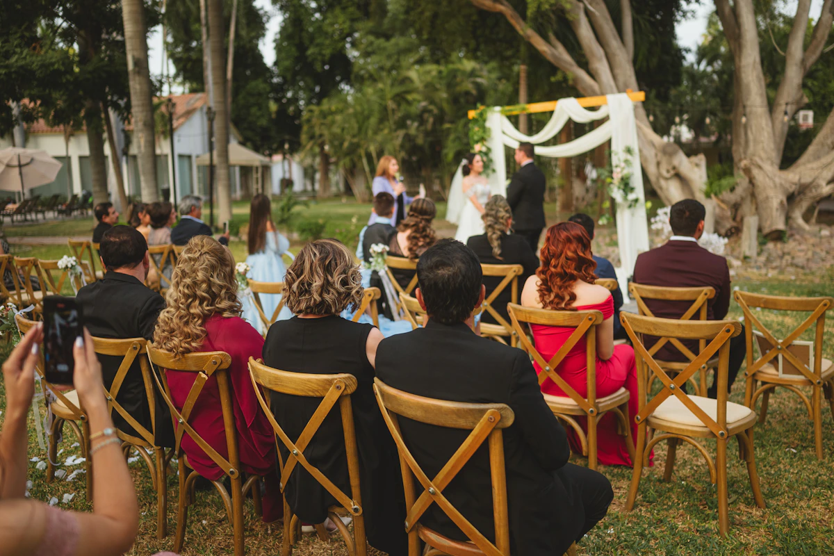 Invités assis dans un jardin pendant une cérémonie en plein air