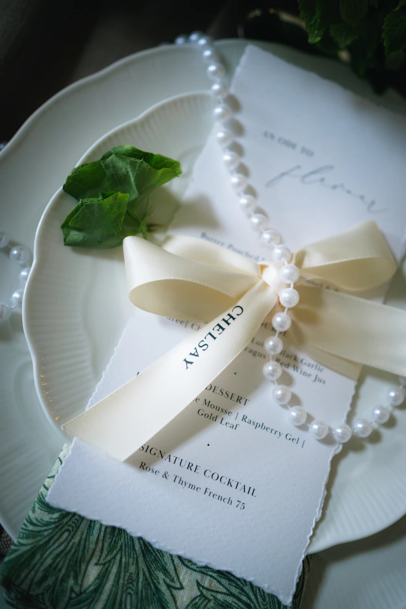 Faire-part de mariage noué d’un ruban et d’un rang de perles