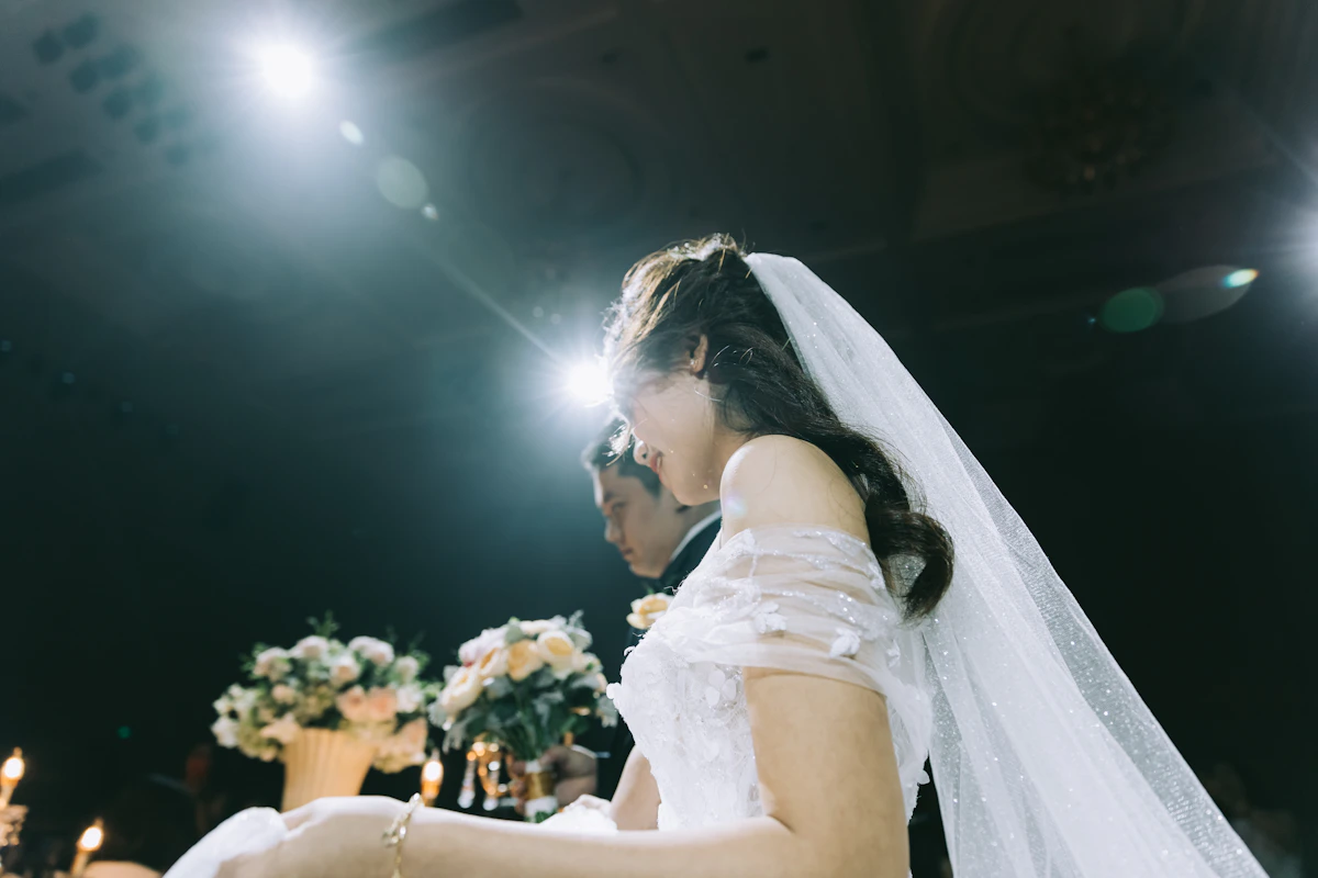 Mariée photographiée au flash pendant la soirée, voile dans la lumière