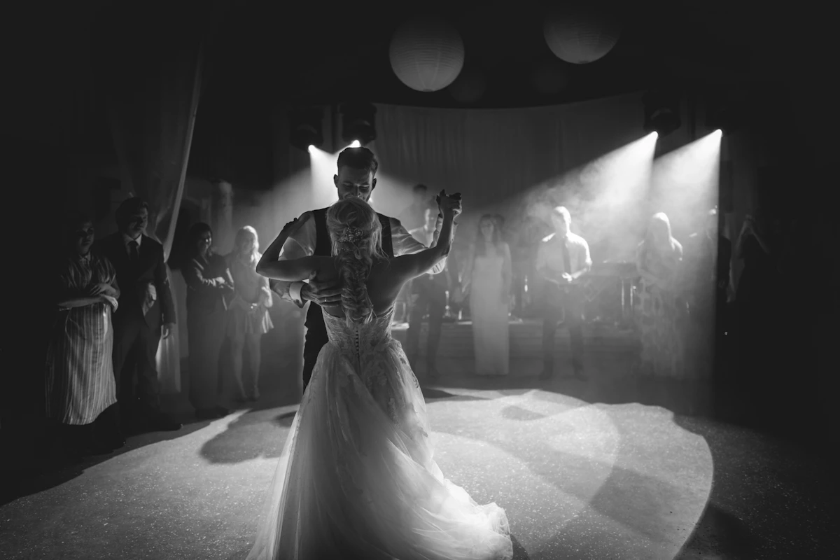 Première danse des mariés sous les projecteurs, en noir et blanc