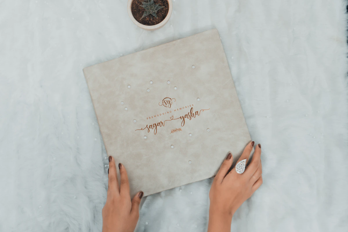 Album photo de mariage à couverture beige tenu à deux mains